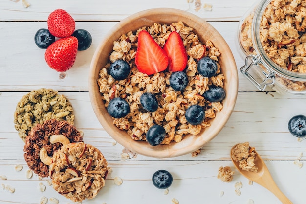 ciotola di granola con bacche fresche, fragola sul tavolo di legno.