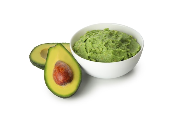 Ciotola di guacamole e avocado isolati su sfondo bianco