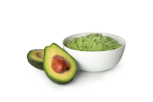 Ciotola di guacamole e avocado isolati su sfondo bianco