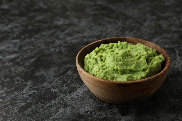 Ciotola di guacamole su sfondo nero smokey, spazio per il testo