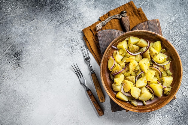 Ciotola di insalata di patate tiepida con pancetta Kartoffelsalat tedesco Sfondo bianco Vista dall'alto Copia spazio