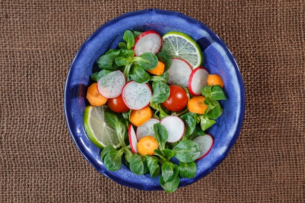 Ciotola di insalata di verdure fresche su tovaglia di iuta