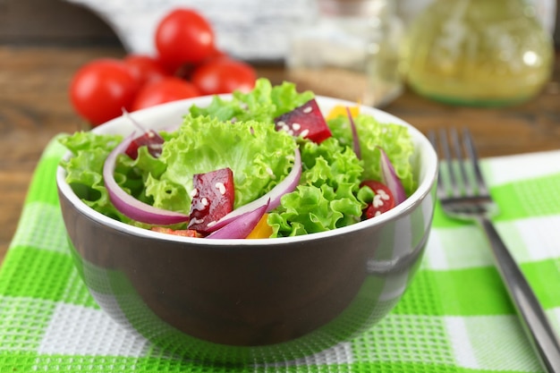 Ciotola di insalata verde fresca sul tavolo con il primo piano del tovagliolo