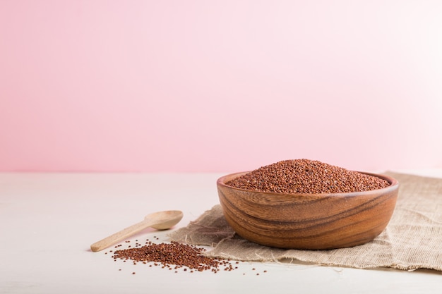 Ciotola di legno con semi di quinoa rossa cruda