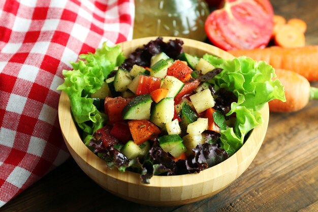 Ciotola di legno di insalata di verdure fresche sulla tavola di legno, primo piano