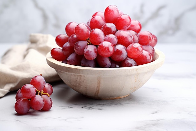 Ciotola di legno di uva rossa fresca su superficie di marmo