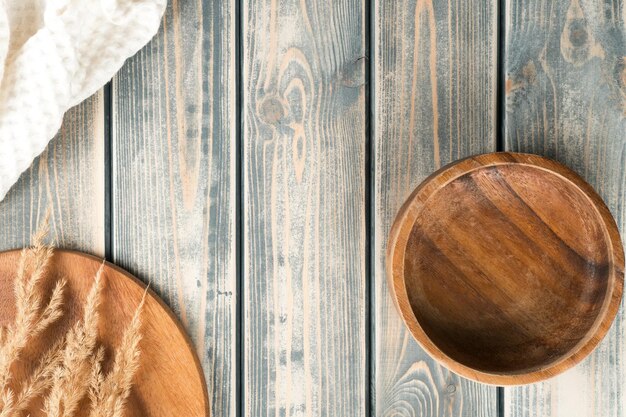 Ciotola di legno vuota sulla superficie rustica del tavolo in legno grigio con vassoio di spighette e asciugamano bianco Copia spazio Vista dall'alto