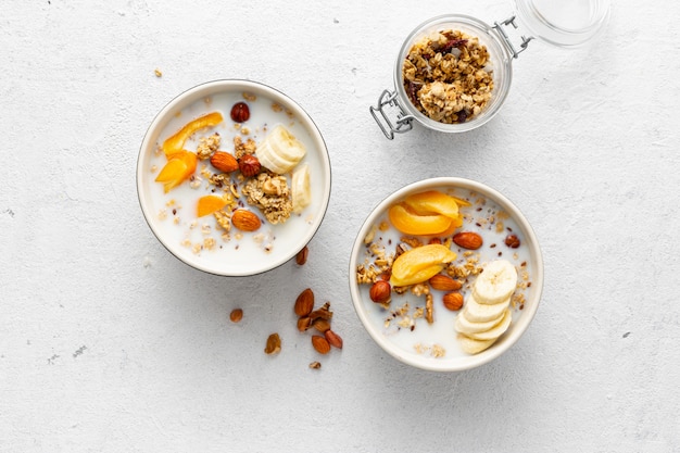 Ciotola di muesli con frutta, noci, latte e burro di arachidi