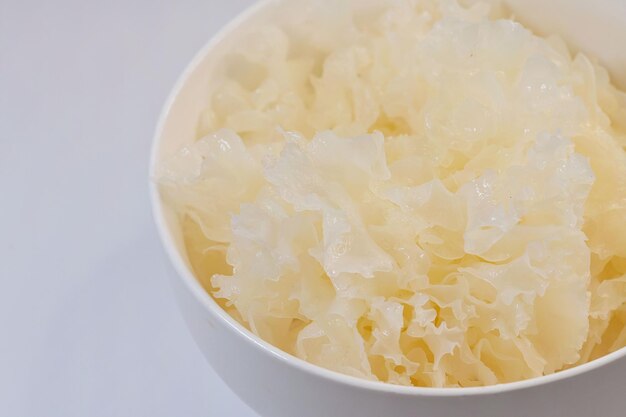 Ciotola di neve reidratata o fungo bianco Tremella fuciformis pronto per il consumo su bianco