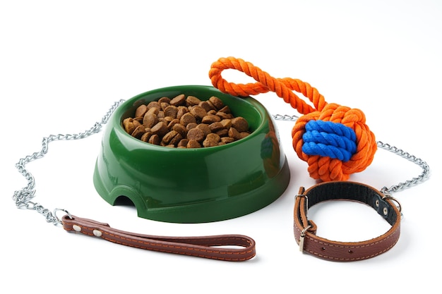 Ciotola di plastica verde con cibo secco per animali domestici isolato su bianco