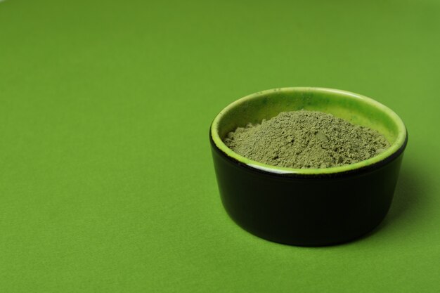 Ciotola di polvere di matcha su sfondo verde