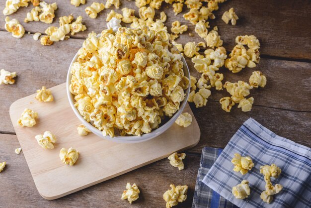 Ciotola di popcorn sulla tavola di legno, fuoco selettivo