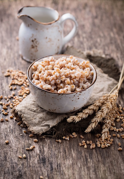 Ciotola di porridge dell&#39;orzo su fondo di legno