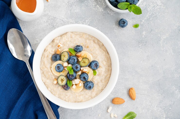 Foto ciotola di porridge di farina d'avena con banana, mirtilli e mandorle