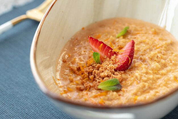 Ciotola di porridge di farina d'avena con fragole e menta