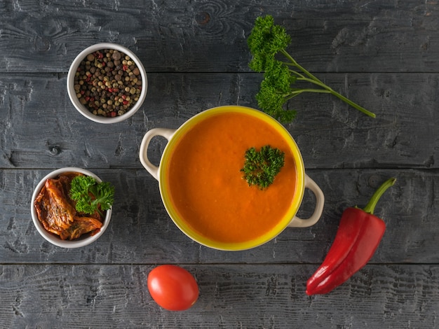 Ciotola di purea di zuppa di peperone e sedano su un tavolo di legno. Zuppa della dieta vegetariana. Lay piatto. La vista dall'alto.