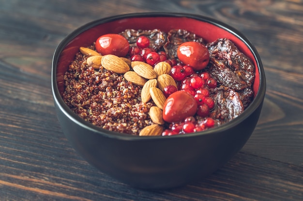 Ciotola di quinoa rossa con noci e pomodori secchi e olive rosse