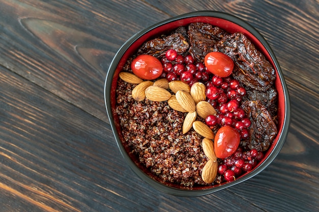 Ciotola di quinoa rossa con noci e pomodori secchi