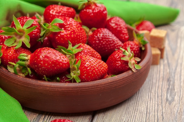 Ciotola di raccolta di fragole sul tavolo di legno da vicino