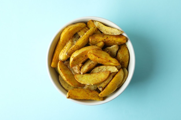 Ciotola di spicchi di patate su sfondo blu