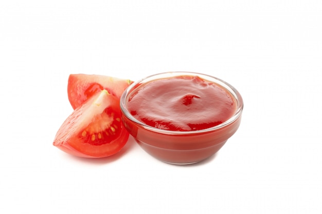 Ciotola di vetro con salsa al pomodoro isolata su fondo bianco