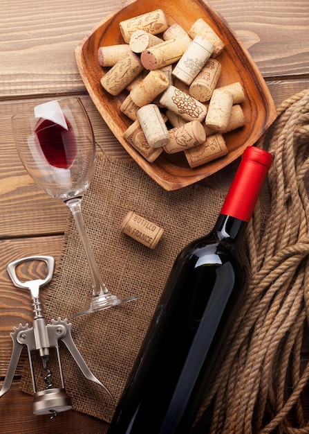 Ciotola di vetro di vino bottiglia di vino rosso con tappi di sughero e cavatappi