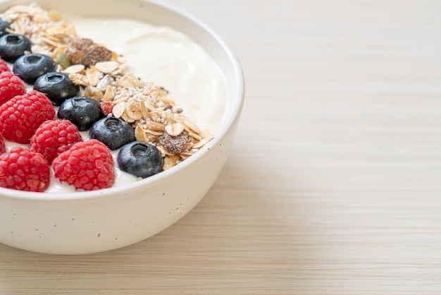 ciotola di yogurt fatta in casa con lampone, mirtillo e muesli - stile alimentare sano