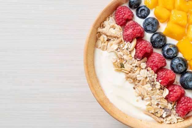 ciotola di yogurt fatta in casa con lampone, mirtillo, mango e muesli - stile alimentare sano healthy