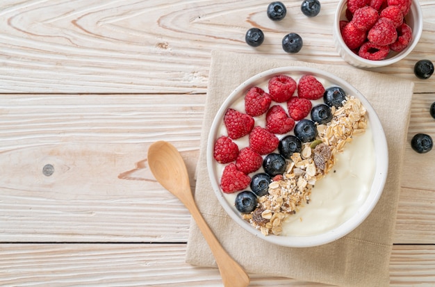 ciotola di yogurt fatto in casa con lamponi, mirtilli e muesli - stile di cibo sano