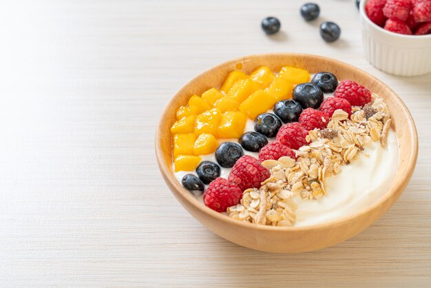 ciotola di yogurt fatto in casa con lamponi, mirtilli, mango e muesli - stile di cibo sano