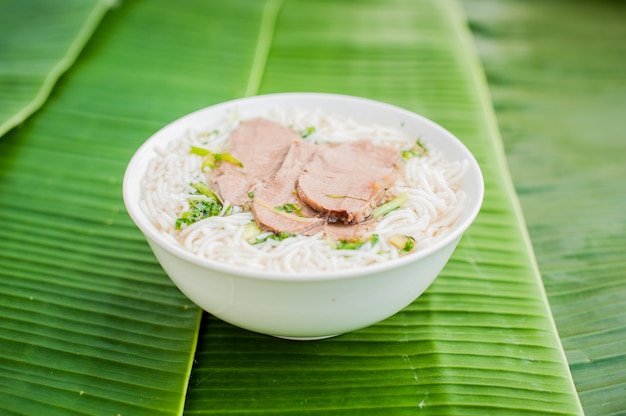 ciotola di zuppa di manzo vietnamita tradizionale Pho Bo su sfondo di foglia di banana.