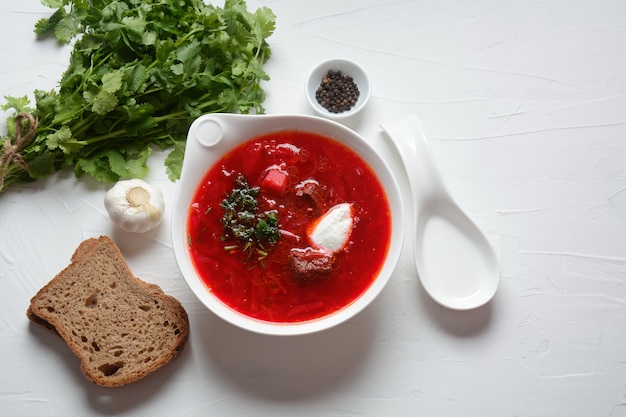 Ciotola di zuppa di radice di barbabietola rossa borsch con crema bianca