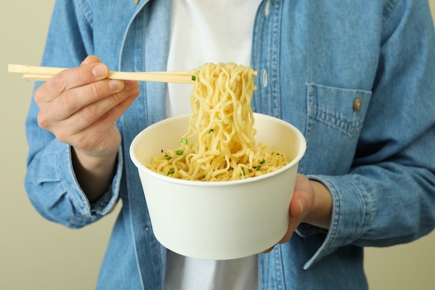 Ciotola e bacchette di carta della stretta della donna con le tagliatelle cotte