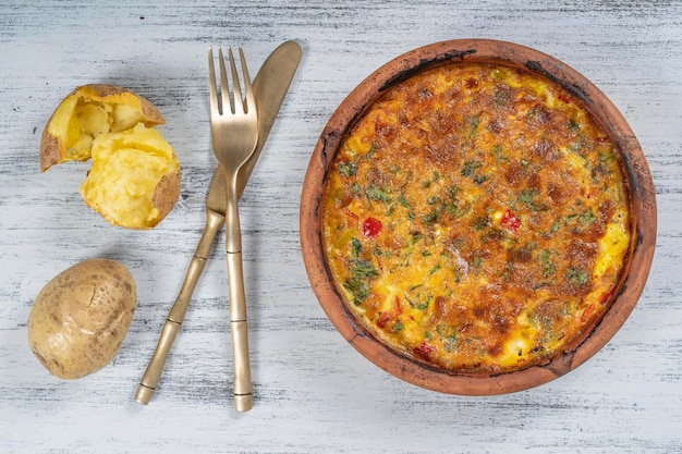 Ciotola in ceramica con frittata di verdure semplice cibo vegetariano Frittata con pomodoro, cipolla e formaggio sul tavolo di legno primo piano frittata di uova italiana vista dall'alto