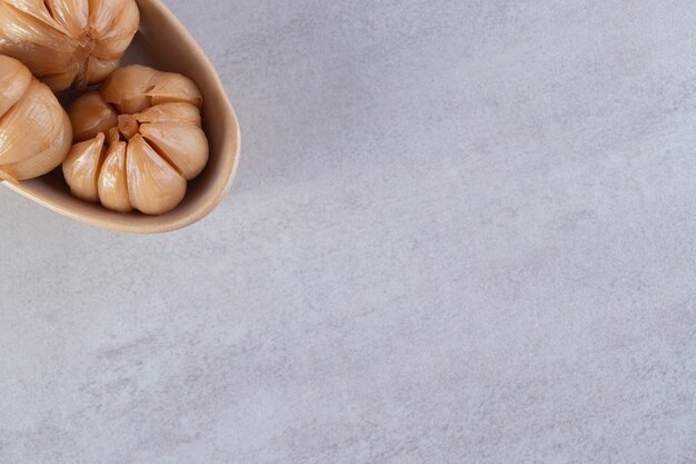 Ciotola in ceramica di aglio sottaceto posto sul tavolo di pietra.