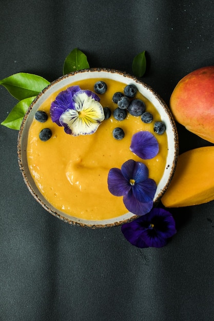 Ciotola per frullato di mango Lassi con curcuma Frutta tropicale fresca su sfondo chiaro Cibo sano