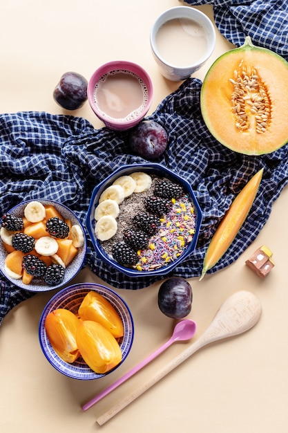 Ciotola per la colazione con farina d'avena, yogurt, more, cachi, melone e semi di chia, vista dall'alto