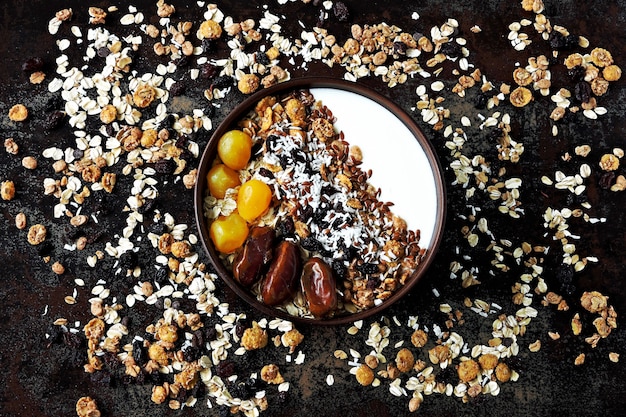 Ciotola per la colazione con yogurt greco, farina d'avena, muesli e frutta secca.