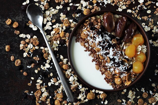 Ciotola per la colazione con yogurt greco, farina d'avena, muesli e frutta secca.