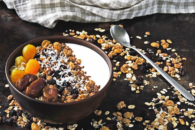 Ciotola per la colazione con yogurt greco, farina d'avena, muesli e frutta secca.