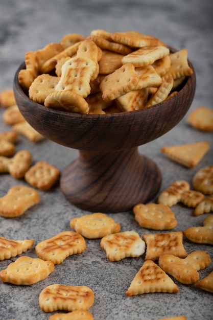 Ciotola piena di cracker croccanti posti su uno sfondo di pietra.