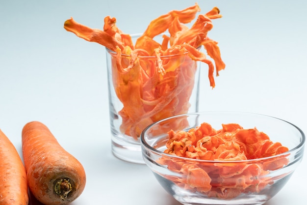 Ciotola trasparente e vetro con scaglie di carota