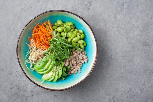 Ciotola vegetariana con carote fresche, avocado, piselli