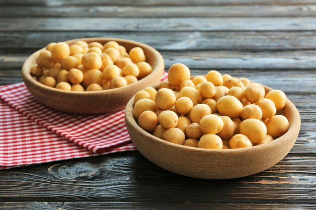 Ciotole con patate biologiche crude su un tavolo di legno