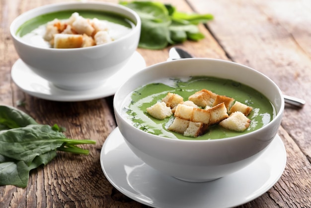 Ciotole con una deliziosa zuppa di spinaci sul tavolo