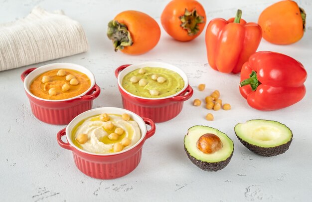 Ciotole di diversi tipi di hummus: classico, avocado e paprika-cachi