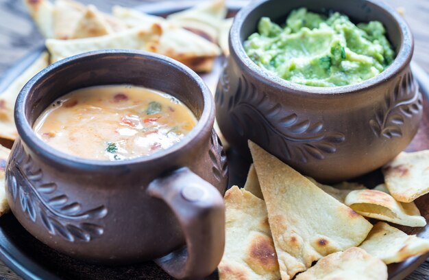 Ciotole di guacamole e queso con tortilla chips