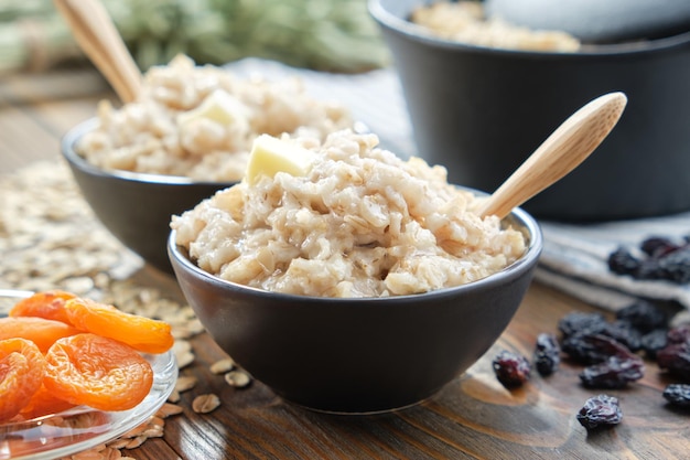 Ciotole di sano porridge di farina d'avena con albicocche secche e uvetta