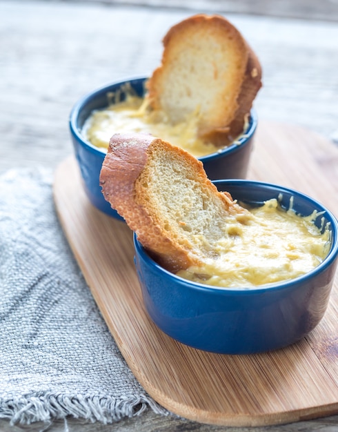 Ciotole di zuppa di cipolle sul bordo di legno