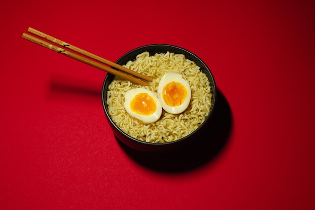 Ciotole di zuppa di ramen con uova e bacchette. Noodles istantanei.